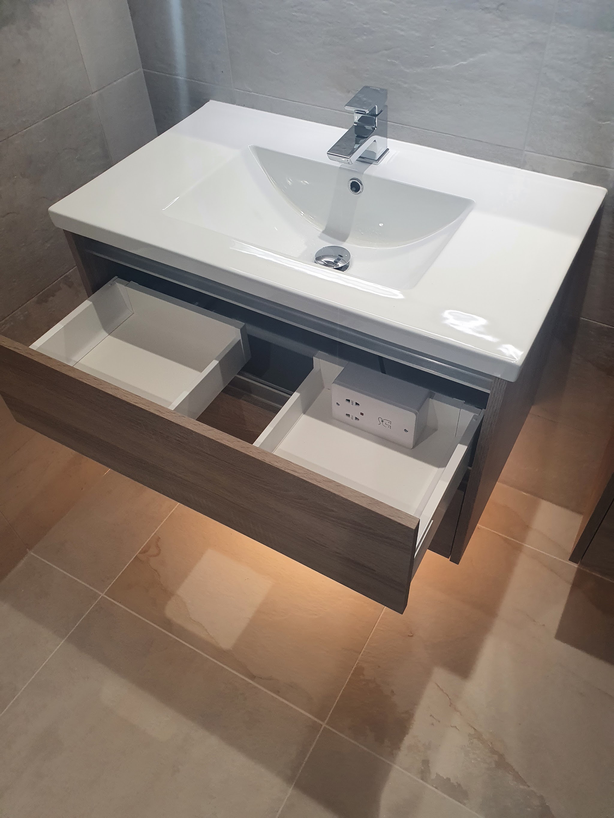 Wall-hung vanity unit with its drawers open under a wide basin