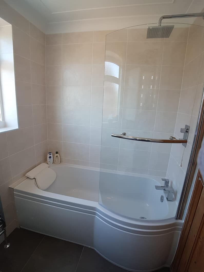 P-shaped shower bath with a curved glass screen