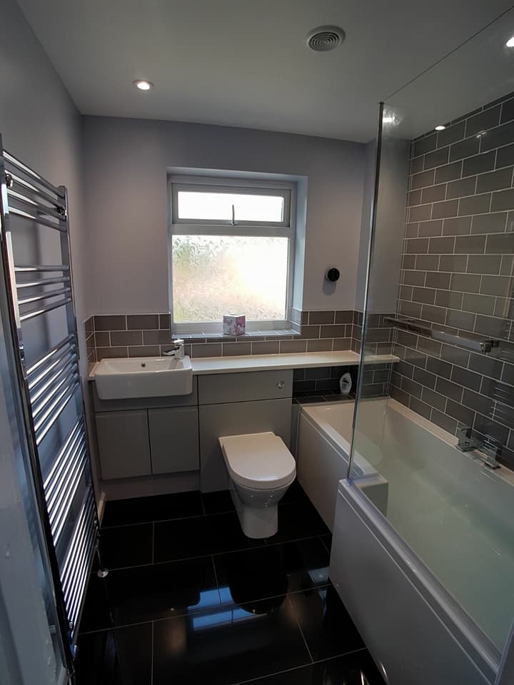 Family bathroom with grey fitted furniture and a chrome towel rail