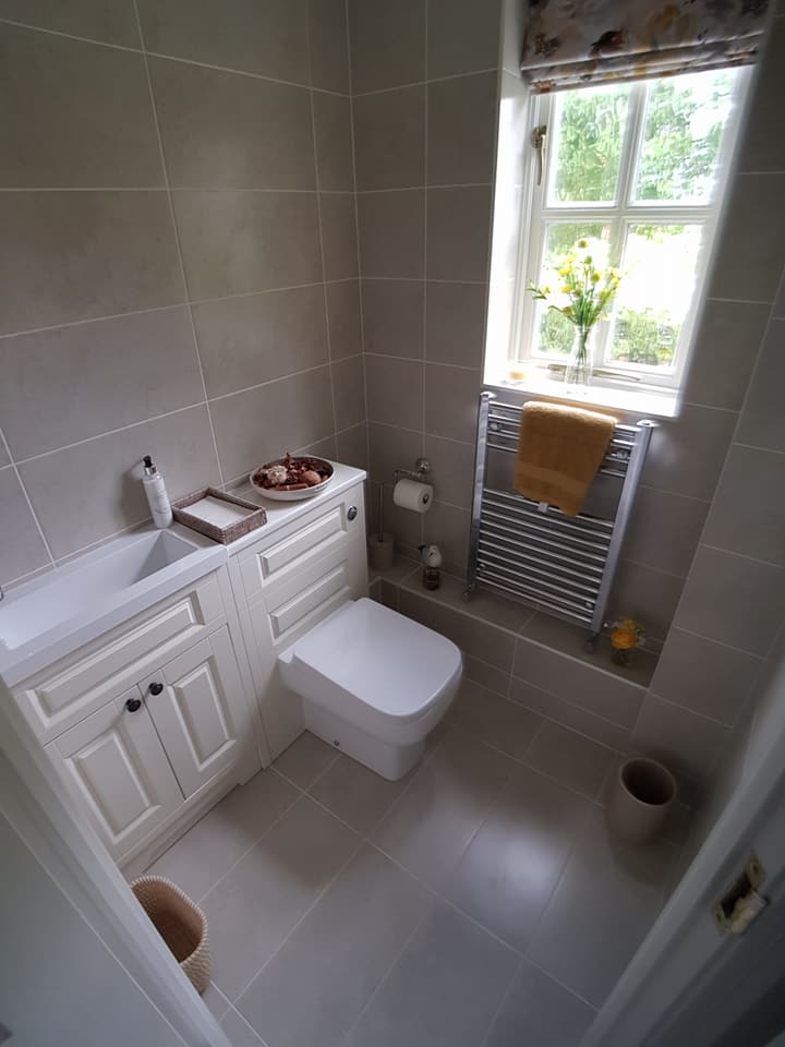 Cloakroom with traditional white fitted furniture under a window