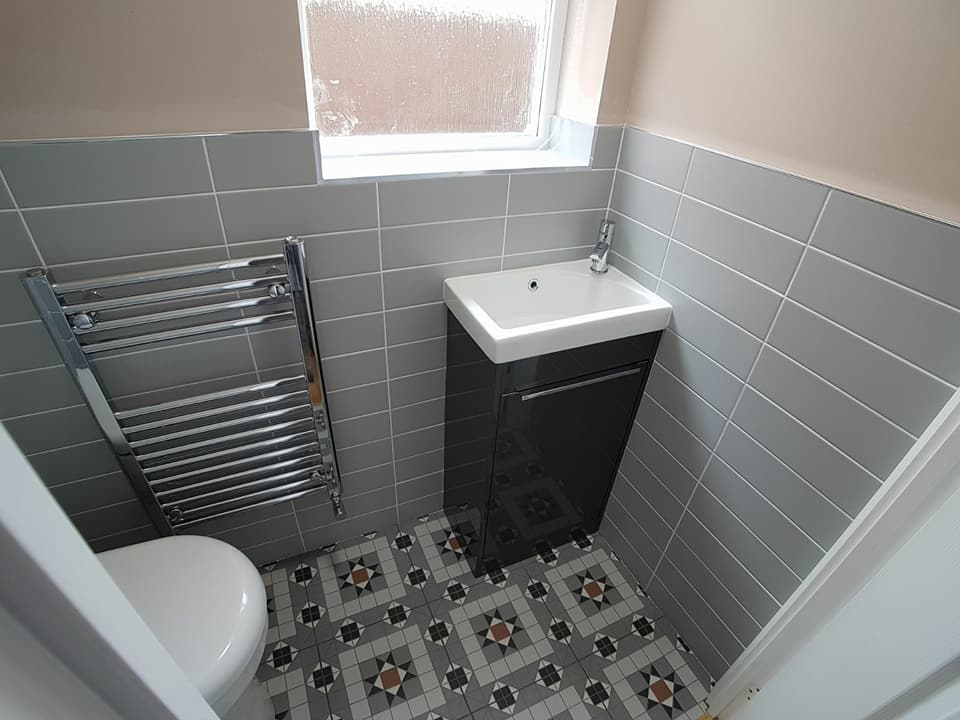 Cloakroom with Victorian-pattern floor tiles and a towel rail