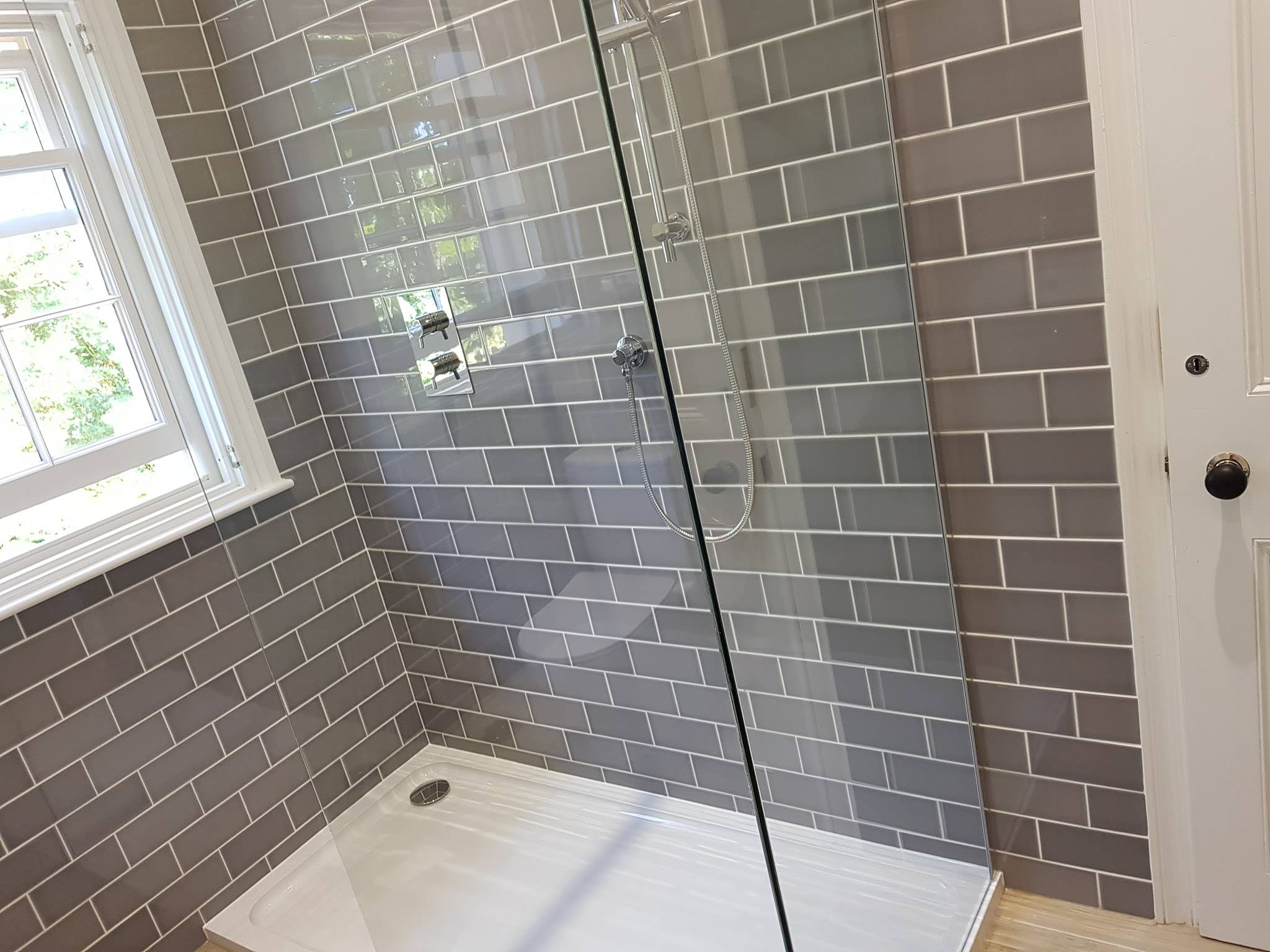 Ensuite with grey metro tiles and a frameless shower screen