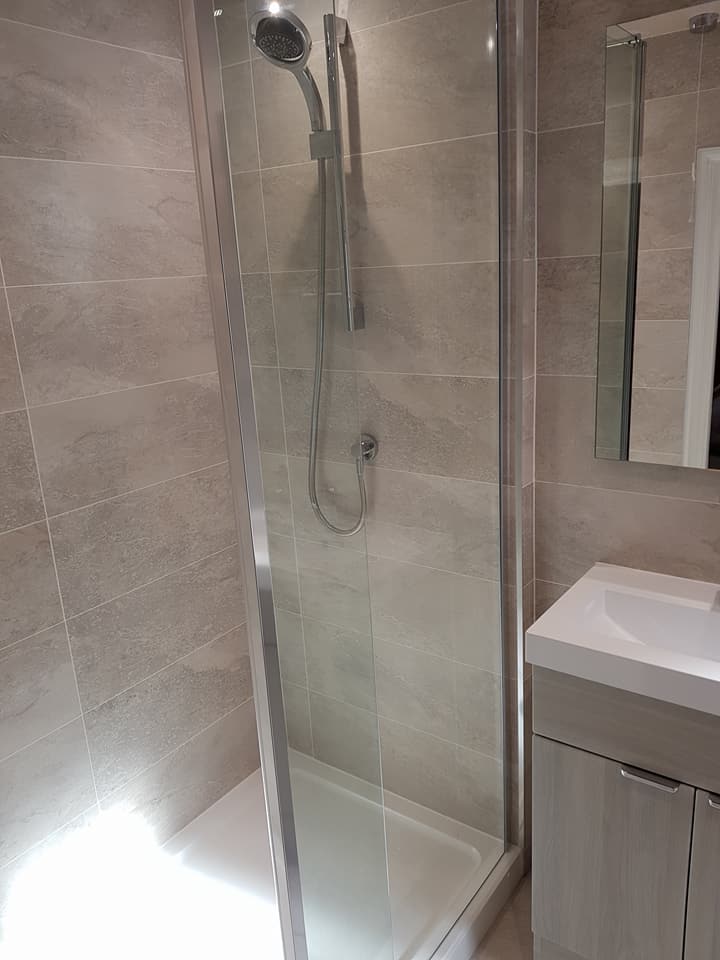 Ensuite shower enclosure with a wood-effect vanity